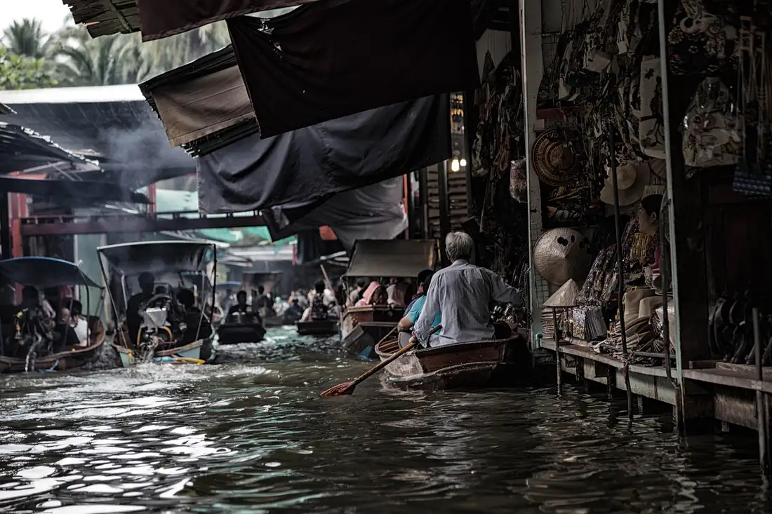 Boats and stalls along a crowded Thai floating market canal